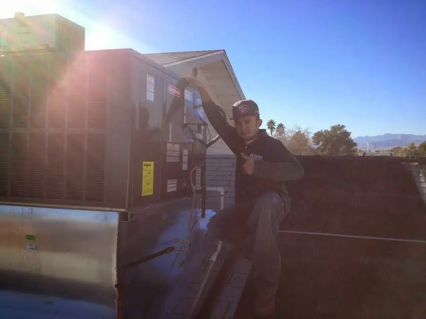 HVAC technician performing HVAC Inspection on a rooftop unit in Rothschild
